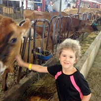 child petting cow