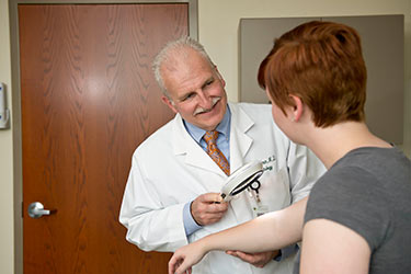 photo of a doctor looking at a patient's skin