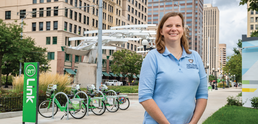 Jennifer Wentzel in front of bikes in downtown Dayton. Jennifer is an M.P.H. program alumni.
