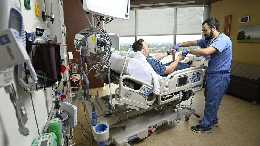 A neurology resident working with a patient in a hospital bed