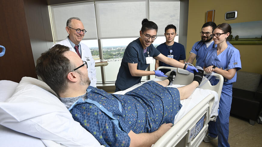 Neurology residents working with a patient at an ICU bed with an attending