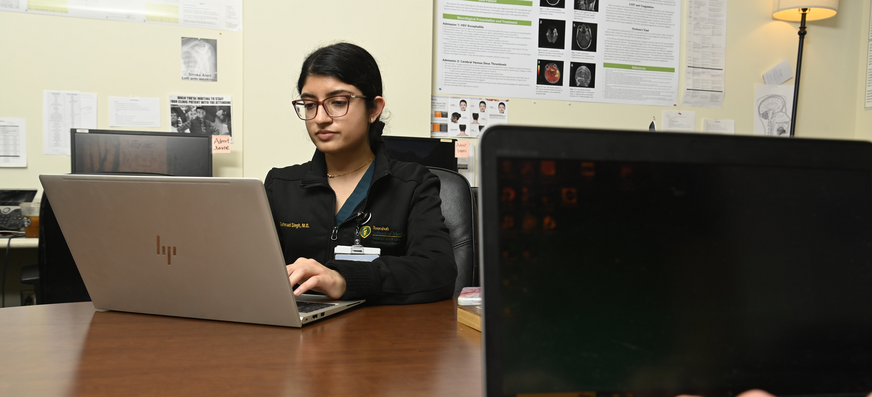 Neurology resident working on a computer