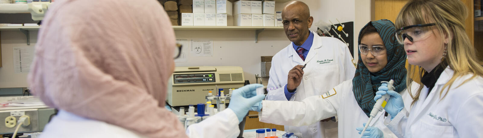 photo of students and a professor in a lab