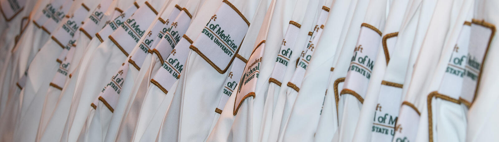 photo of a rack of white coats