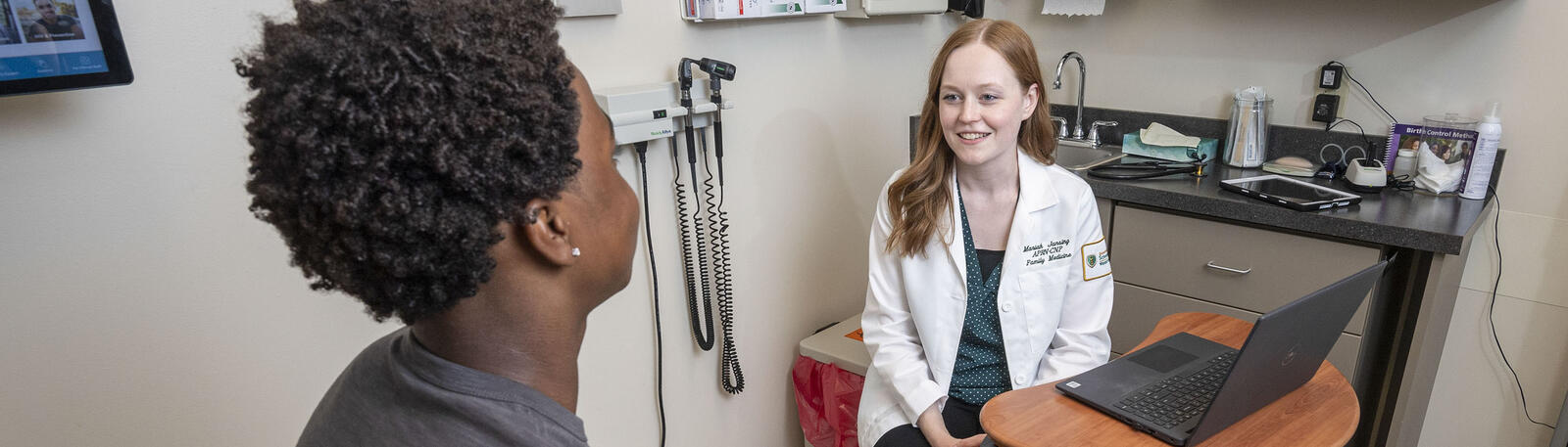 photo of resident and patient in an exam room