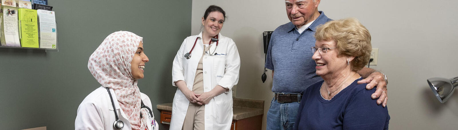 photo of a resident and patients in an exam room