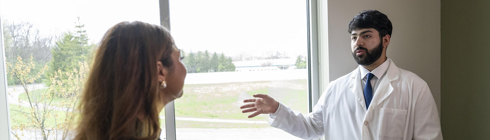 a patient and resident talking in an exam room