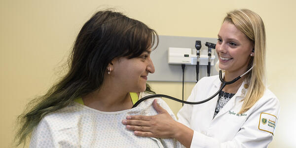 photo of a student and simulated patient in an exam room