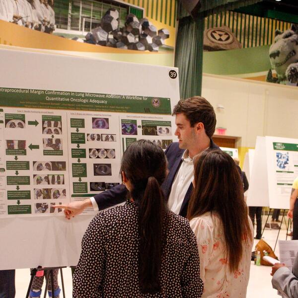 researcher explains his poster