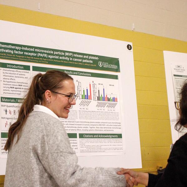 researcher standing next to poster