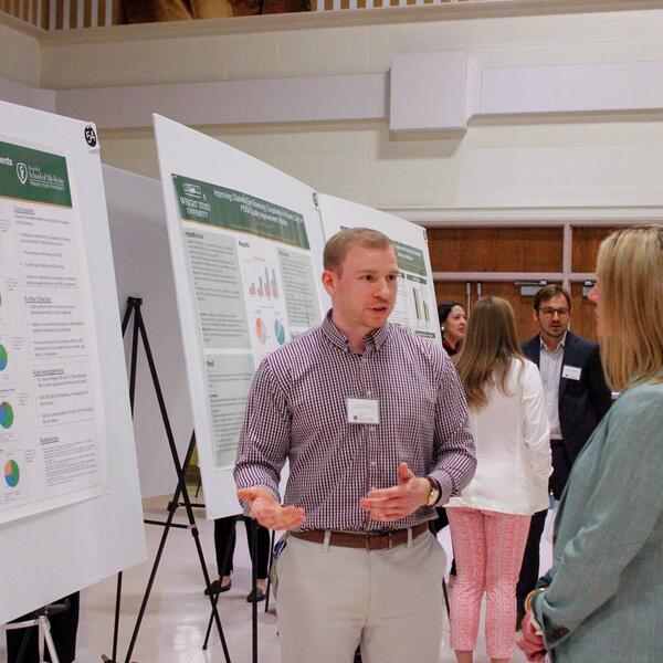 researcher showing their poster