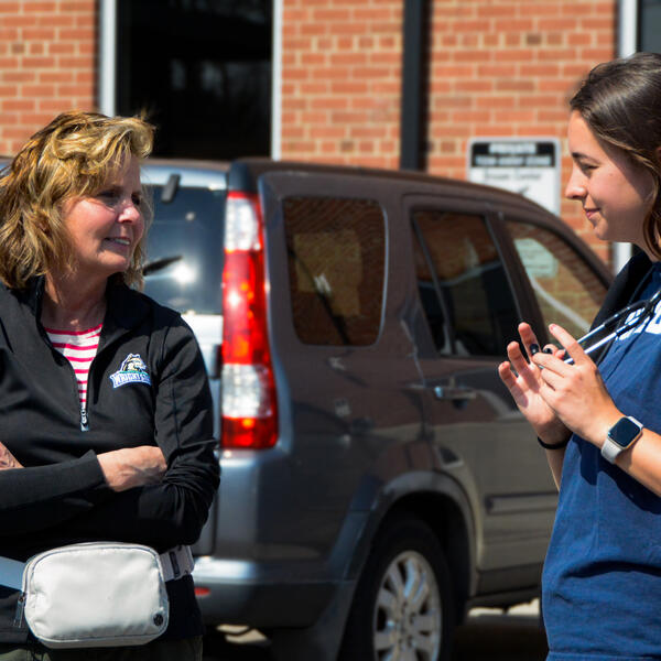 photo of two people talking in a parking lot