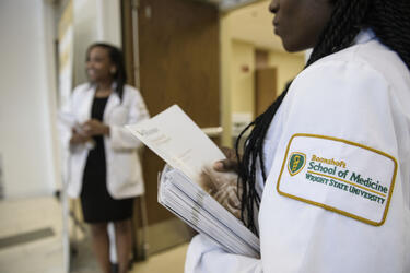 photo of students giving out programs at a school event