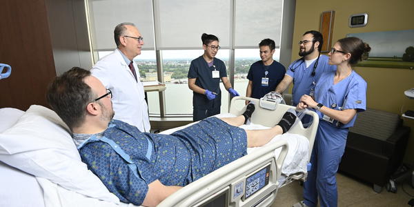 Neurology residents talking with attending and patient